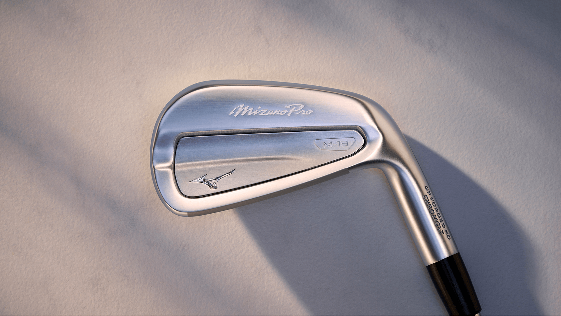 Close-up of a Mizuno golf iron club showing its polished finish and ergonomic design