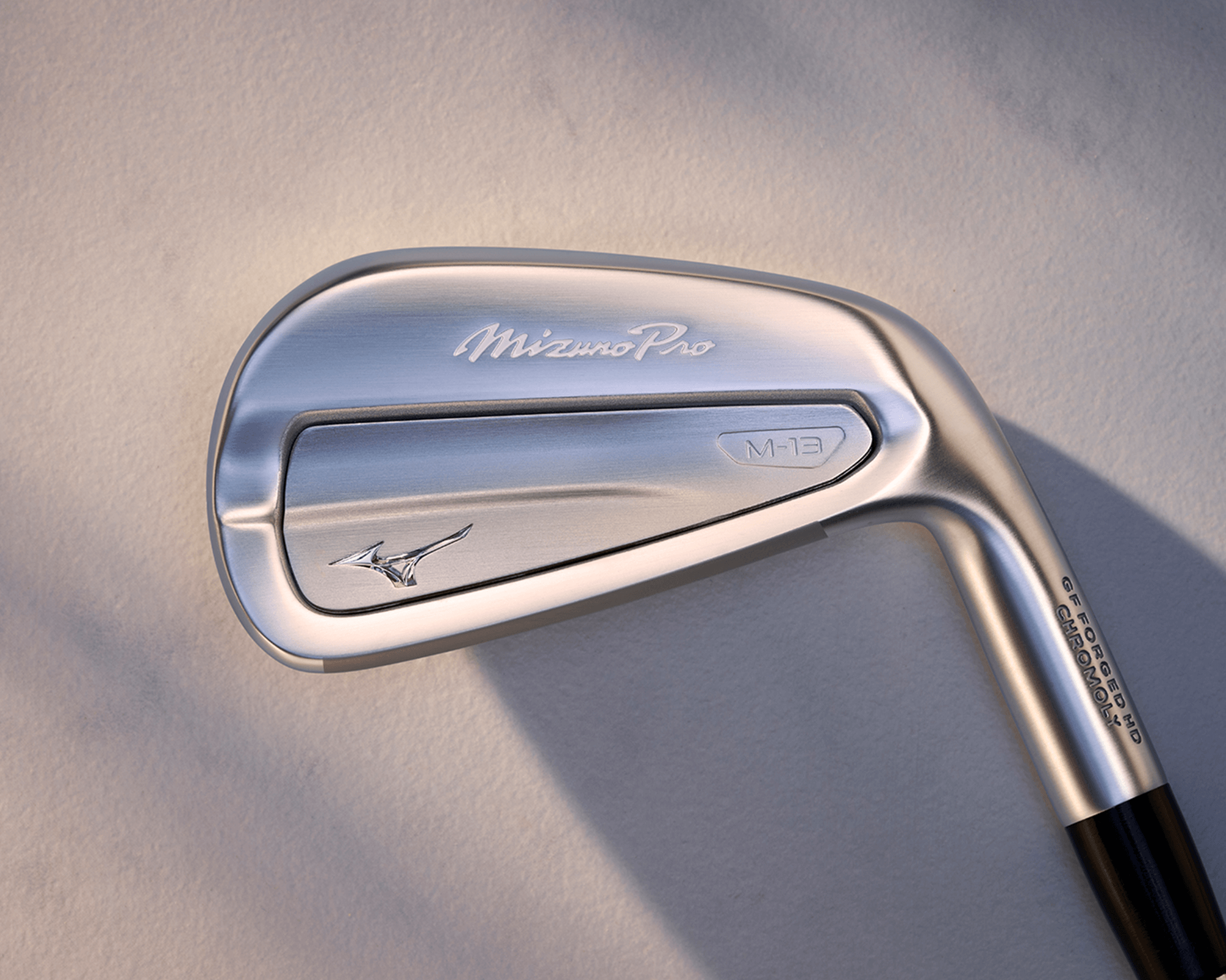 Close-up image of a Mizuno Pro golf iron club head, showcasing its sleek design and branding.